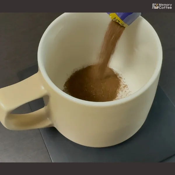 Memory Coffeeのスティックから粉末をマグカップに入れている接写画像。