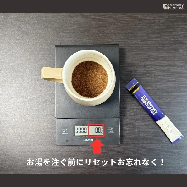 Memory Coffeeの粉末をマグカップに入れ終えた直後の画像。正確なお湯の量を測るため、スケールのゼロポジションのリセットボタンを押し忘れないように喚起しています。