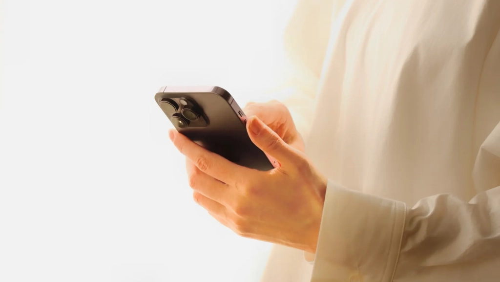 スマートフォンを持っている女性の手。